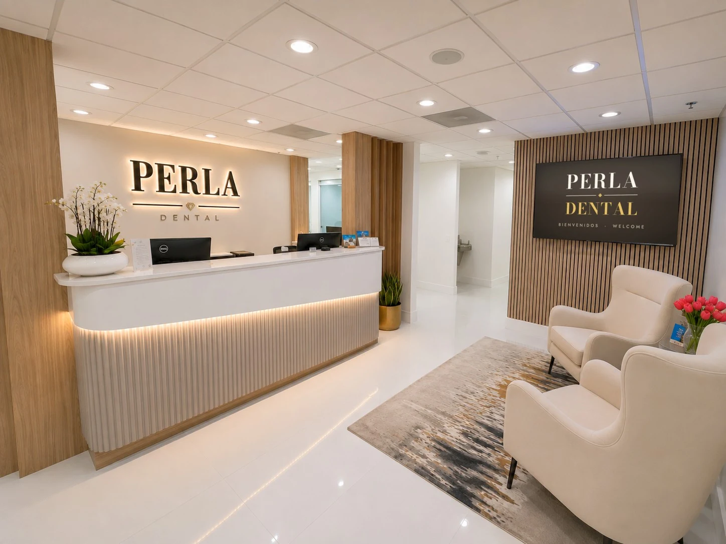 The Perla Dental reception: the lit PERLA sign above the front desk, and armchairs beneath a welcome screen