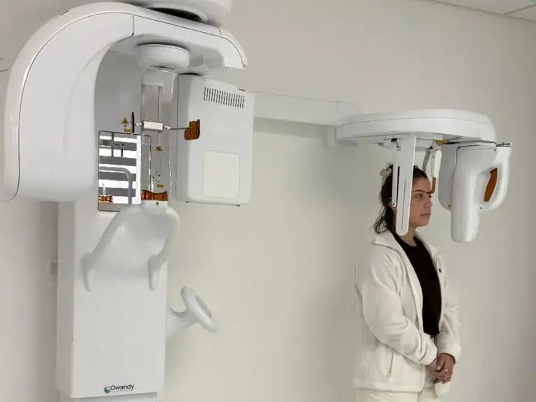 A patient standing in the 3D CBCT scanner at Perla Dental